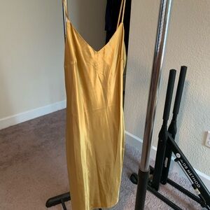 Gold satiny spaghetti strap sheath dress.
